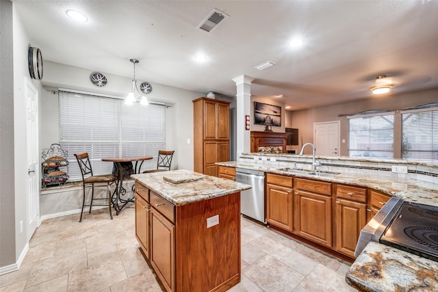 kitchen featuring a sink, brown cabinetry, stainless steel appliances, visible vents, and a kitchen island