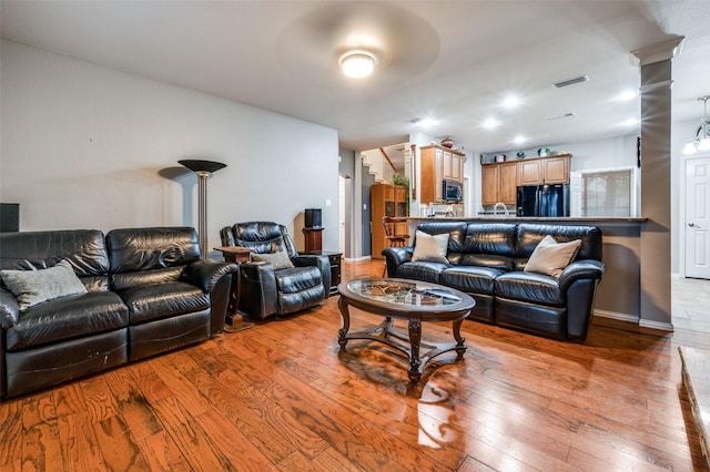 living area with hardwood / wood-style floors and visible vents