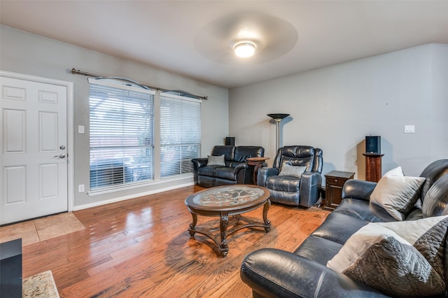 living room featuring wood finished floors, baseboards, and ceiling fan