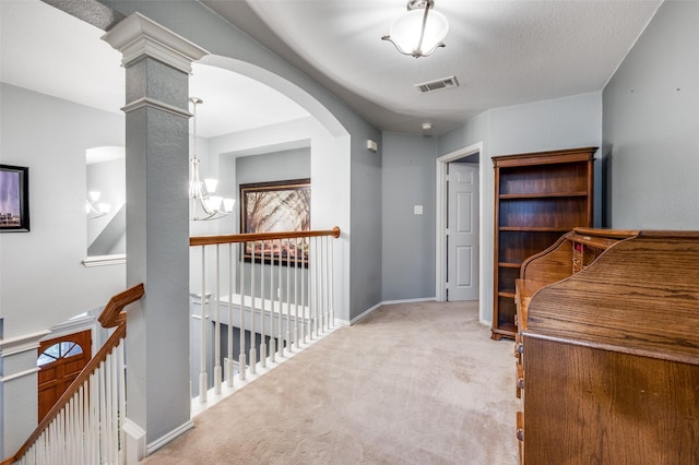 hallway featuring carpet, an upstairs landing, visible vents, a chandelier, and arched walkways