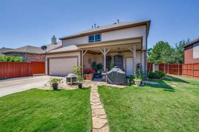 back of property featuring a garage, a ceiling fan, a lawn, concrete driveway, and a fenced backyard