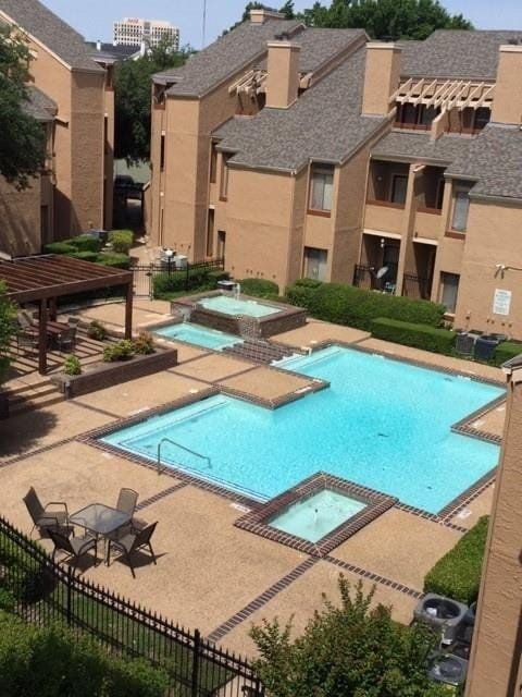 5550 Spring Valley Rd Unit F12, Dallas, TX 75254 - view of swimming pool with a pool with connected hot tub, a patio area, and fence