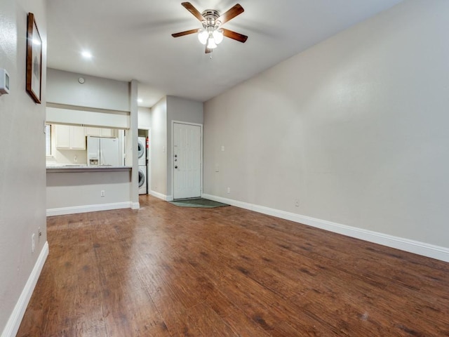 5550 Spring Valley Rd Unit F12, Dallas, TX 75254 - unfurnished living room featuring stacked washing machine and dryer, a ceiling fan, wood finished floors, baseboards, and recessed lighting