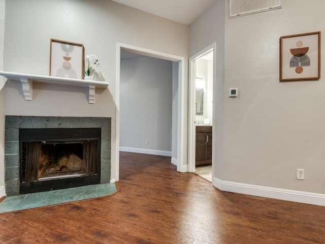 5550 Spring Valley Rd Unit F12, Dallas, TX 75254 - unfurnished living room with wood finished floors, baseboards, and a tile fireplace