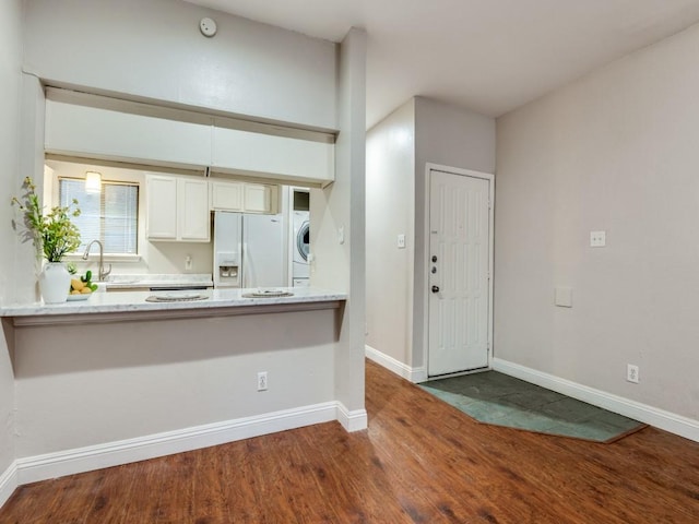 5550 Spring Valley Rd Unit F12, Dallas, TX 75254 - kitchen featuring white fridge with ice dispenser, wood finished floors, baseboards, a peninsula, and white cabinetry