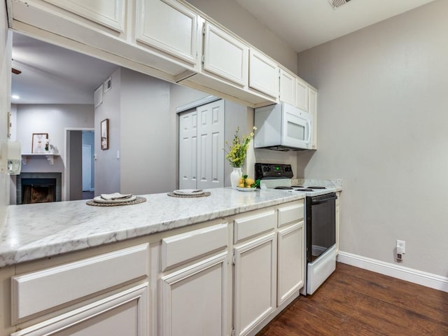 5550 Spring Valley Rd Unit F12, Dallas, TX 75254 - kitchen featuring range with electric cooktop, white microwave, baseboards, dark wood-style flooring, and a fireplace