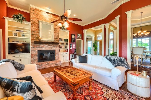 900 Fm 1139, Rockwall, TX 75032 - living room featuring a fireplace, crown molding, ceiling fan with notable chandelier, and decorative columns