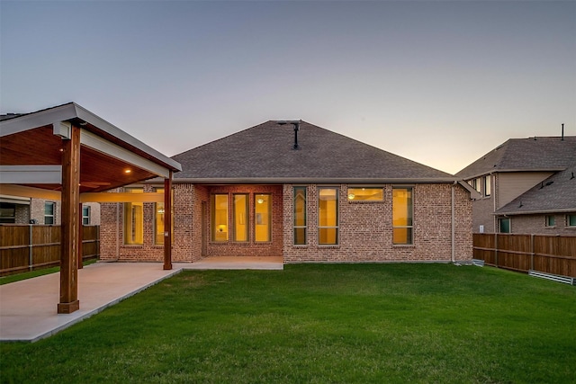 1451 Silver Sage Dr, Haslet, TX 76052 - back of house at dusk with a patio, brick siding, and a shingled roof