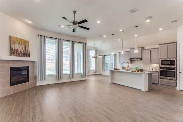 1451 Silver Sage Dr, Haslet, TX 76052 - kitchen with oven, open floor plan, gray cabinets, built in microwave, and ceiling fan