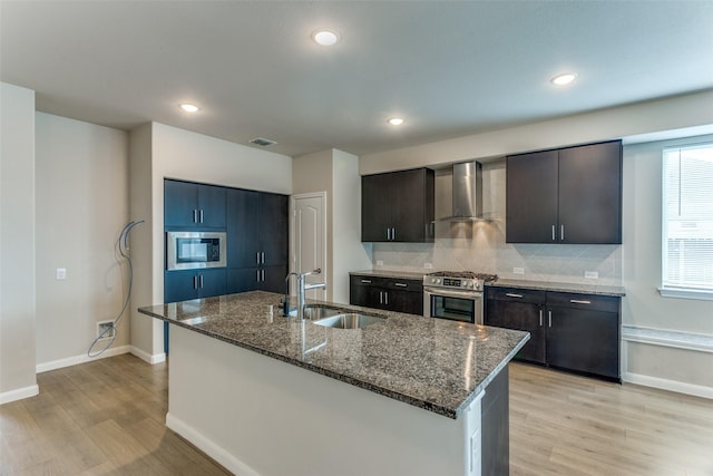 4444 Pentridge Dr, Fort Worth, TX 76036 - kitchen with baseboards, a sink, wall chimney exhaust hood, stainless steel appliances, and light wood-type flooring
