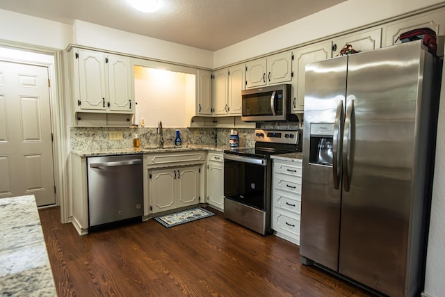 2100 Albert Broadfoot, Bonham, TX 75418 - kitchen featuring appliances with stainless steel finishes, a sink, dark wood-type flooring, and light stone countertops