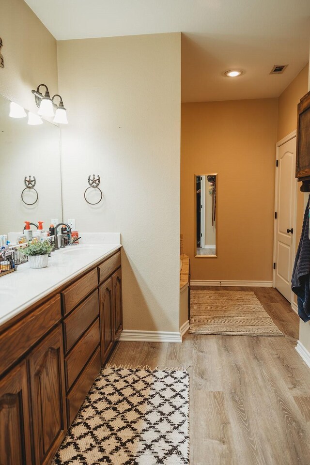 710 Mockingbird St, Bonham, TX 75418 - bathroom with vanity, baseboards, visible vents, and wood finished floors