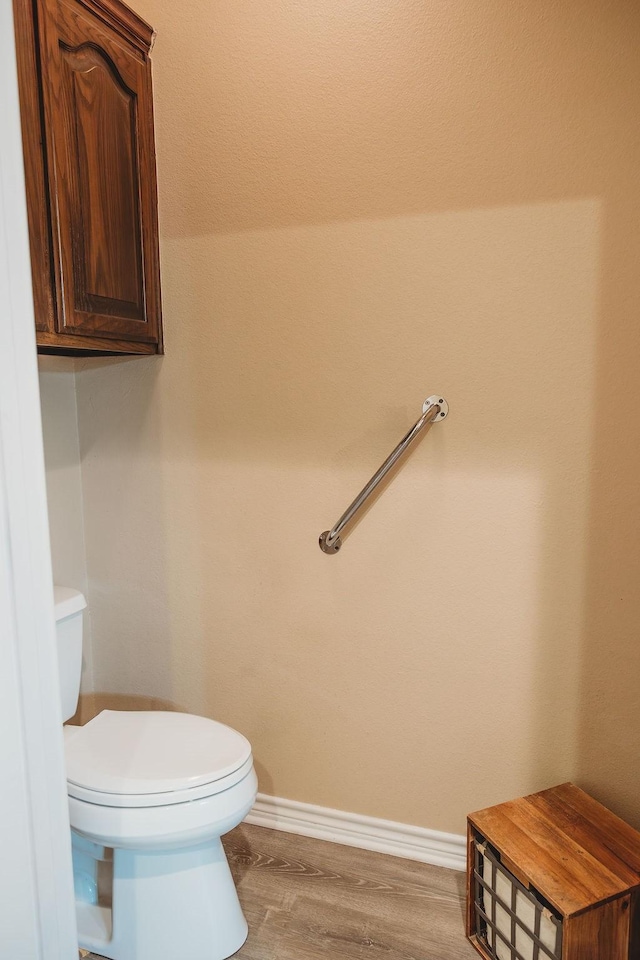 710 Mockingbird St, Bonham, TX 75418 - bathroom featuring toilet, baseboards, and wood finished floors