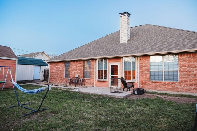 710 Mockingbird St, Bonham, TX 75418 - rear view of property with a yard, a patio area, brick siding, and a shed