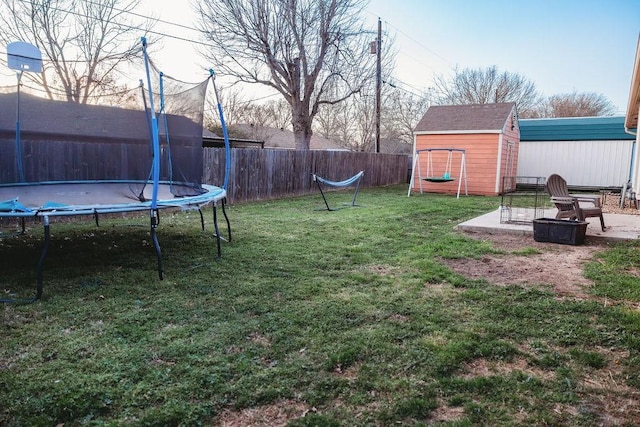 710 Mockingbird St, Bonham, TX 75418 - view of yard featuring a fenced backyard, an outdoor structure, a trampoline, and a storage unit