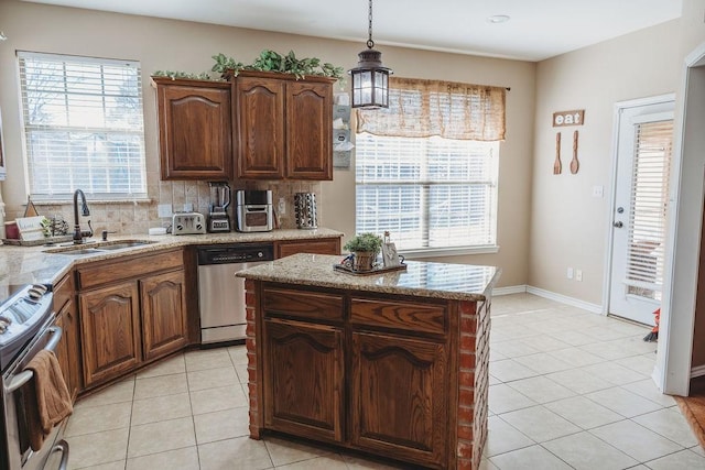 710 Mockingbird St, Bonham, TX 75418 - kitchen featuring decorative light fixtures, light tile patterned floors, a sink, backsplash, and stainless steel appliances