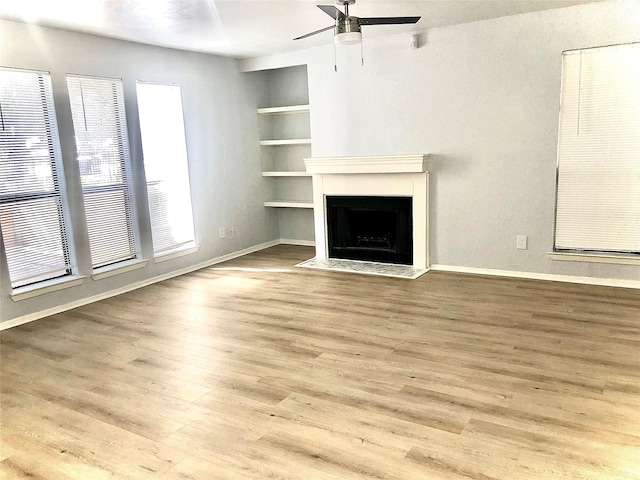 9601 Walnut St Unit 5101, Dallas, TX 75243 - unfurnished living room featuring ceiling fan, built in features, wood finished floors, and a fireplace with flush hearth
