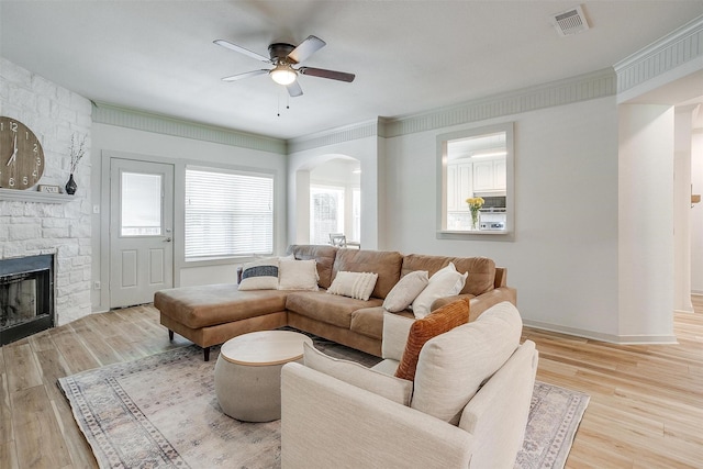 3711 Winding Way, Granbury, TX 76049 - living room with wood finished floors, a ceiling fan, a fireplace, visible vents, and arched walkways