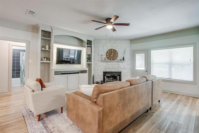 3711 Winding Way, Granbury, TX 76049 - living area featuring light wood finished floors, a fireplace, visible vents, baseboards, and ceiling fan