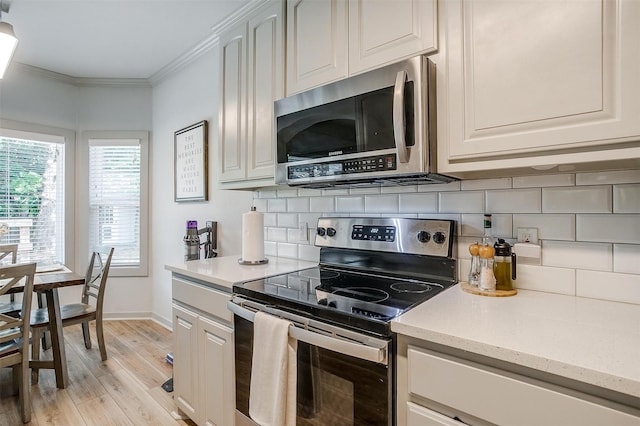 3711 Winding Way, Granbury, TX 76049 - kitchen featuring light wood-style floors, crown molding, baseboards, appliances with stainless steel finishes, and decorative backsplash