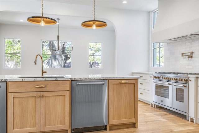 2212 Ridge Crest Dr, Richardson, TX 75080 - kitchen with light wood-style flooring, a sink, custom range hood, backsplash, and appliances with stainless steel finishes