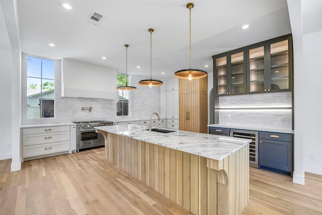2212 Ridge Crest Dr, Richardson, TX 75080 - kitchen featuring a sink, visible vents, backsplash, high end range, and beverage cooler