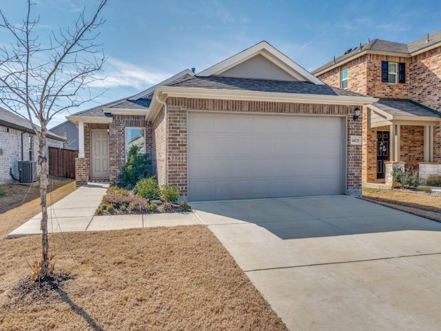 view of front of property with an attached garage, cooling unit, concrete driveway, a shingled roof, and brick siding