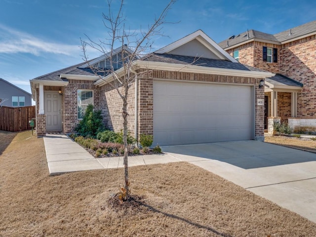 view of front facade featuring an attached garage, concrete driveway, brick siding, and fence