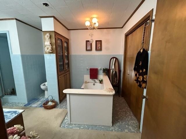 full bathroom with crown molding, toilet, and a wainscoted wall