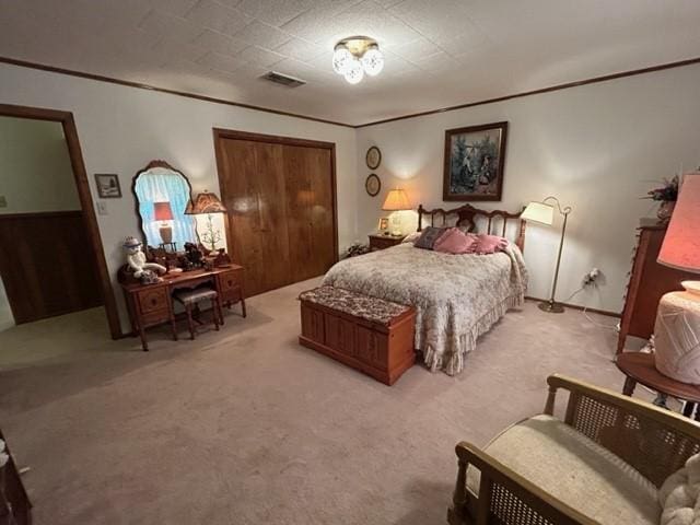 bedroom featuring crown molding, visible vents, and light carpet