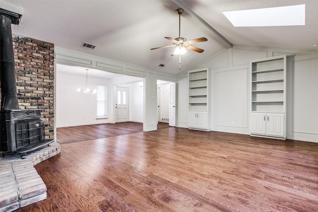 2 Preston Trail Ct, Pantego, TX 76013 - unfurnished living room with wood finished floors, ceiling fan with notable chandelier, visible vents, built in features, and a wood stove