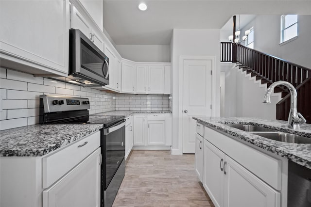 121 County Road 3471, Paradise, TX 76073 - kitchen with light stone countertops, a sink, backsplash, stainless steel appliances, and white cabinets