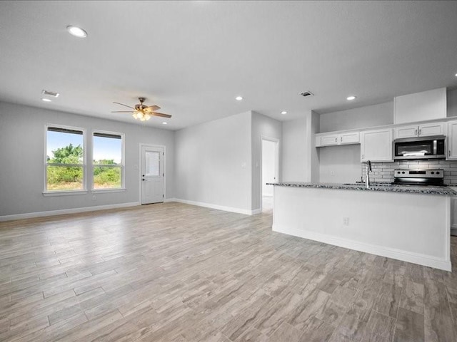 121 County Road 3471, Paradise, TX 76073 - unfurnished living room with a sink, ceiling fan, baseboards, and light wood-style floors