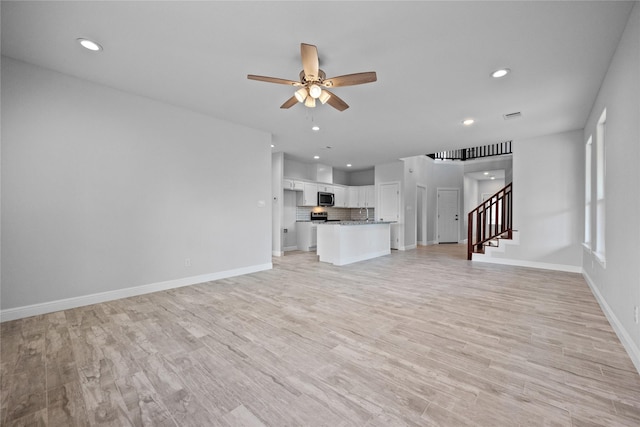 121 County Road 3471, Paradise, TX 76073 - unfurnished living room with recessed lighting, baseboards, ceiling fan, stairs, and light wood-type flooring