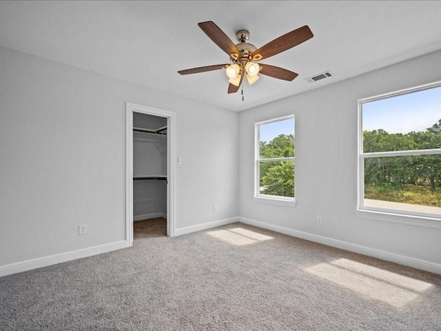 121 County Road 3471, Paradise, TX 76073 - unfurnished bedroom featuring carpet, baseboards, ceiling fan, visible vents, and a walk in closet