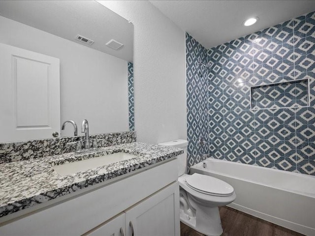 121 County Road 3471, Paradise, TX 76073 - bathroom featuring toilet, wood finished floors, vanity, visible vents, and bathtub / shower combination