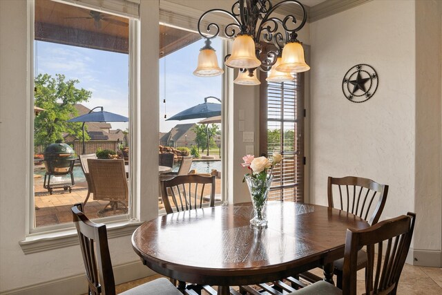 dining area with crown molding, a textured wall, and a chandelier