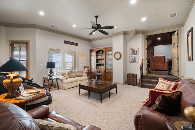 living room with ornamental molding, carpet flooring, a ceiling fan, and visible vents