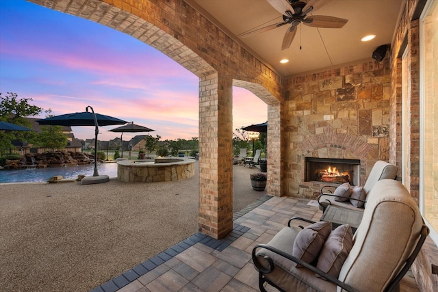 view of patio featuring ceiling fan and an outdoor stone fireplace