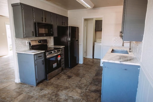 521 E 8th St, Bonham, TX 75418 - kitchen featuring washer / dryer, ornamental molding, black appliances, backsplash, and light countertops