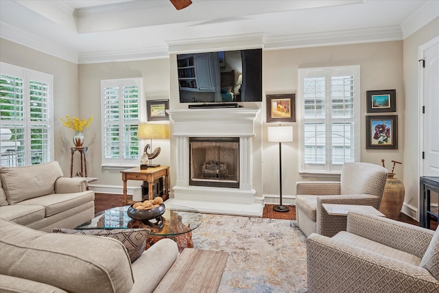 living room with crown molding, a fireplace, and a healthy amount of sunlight