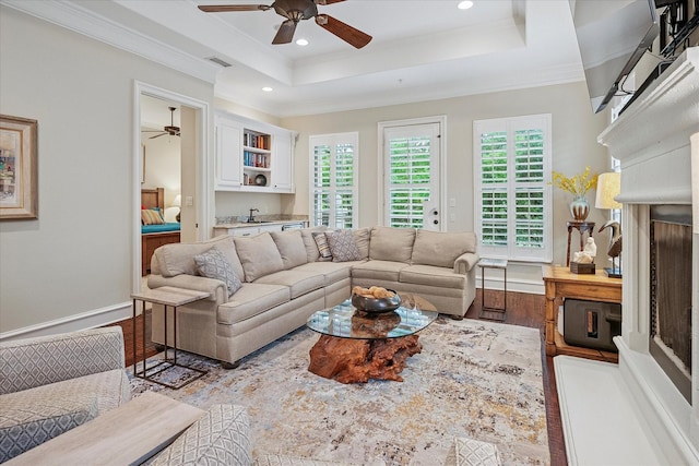 living area with a ceiling fan, ornamental molding, recessed lighting, and wood finished floors