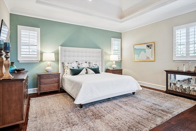 bedroom with ornamental molding, baseboards, and wood finished floors