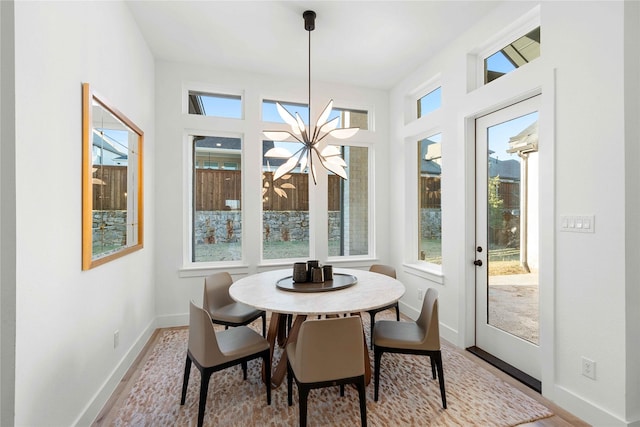 dining space with a chandelier, wood finished floors, and plenty of natural light