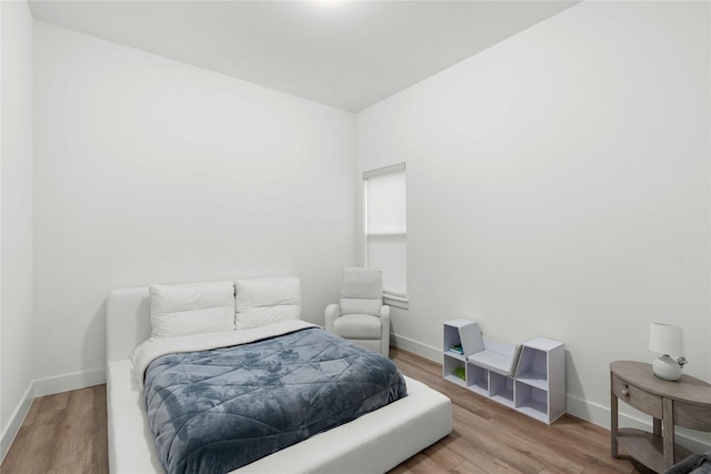 bedroom featuring baseboards and wood finished floors