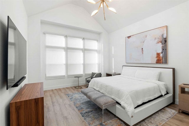 bedroom featuring lofted ceiling, wood finished floors, and a chandelier