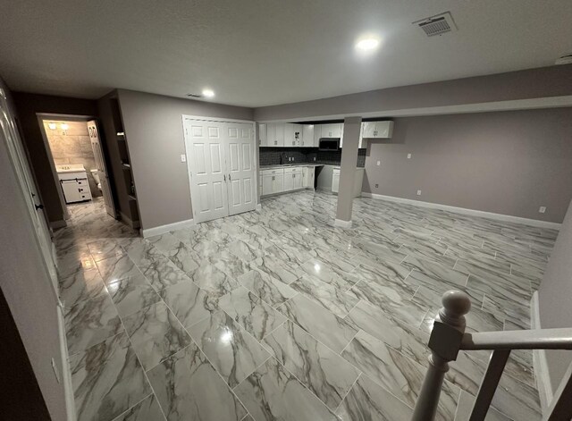 414 Ussery, Bowie, TX 76230 - unfurnished living room with marble finish floor, visible vents, and baseboards