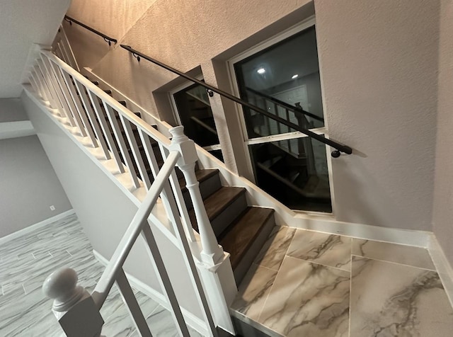 414 Ussery, Bowie, TX 76230 - stairs featuring baseboards, marble finish floor, and a textured wall