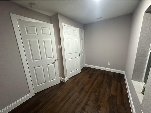 414 Ussery, Bowie, TX 76230 - unfurnished bedroom featuring a closet, visible vents, dark wood-style flooring, and baseboards