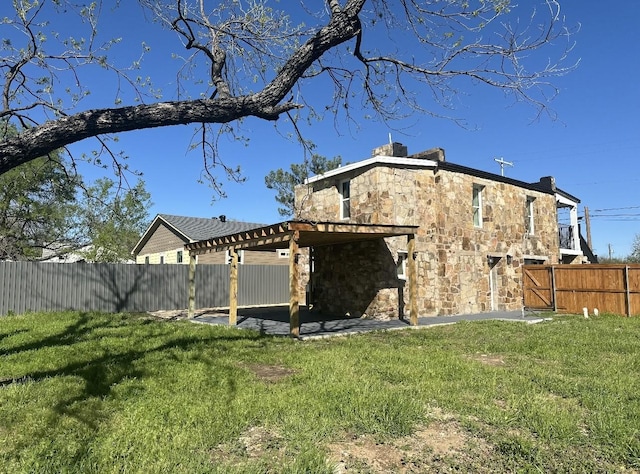 414 Ussery, Bowie, TX 76230 - exterior space featuring a lawn, stone siding, and a fenced backyard